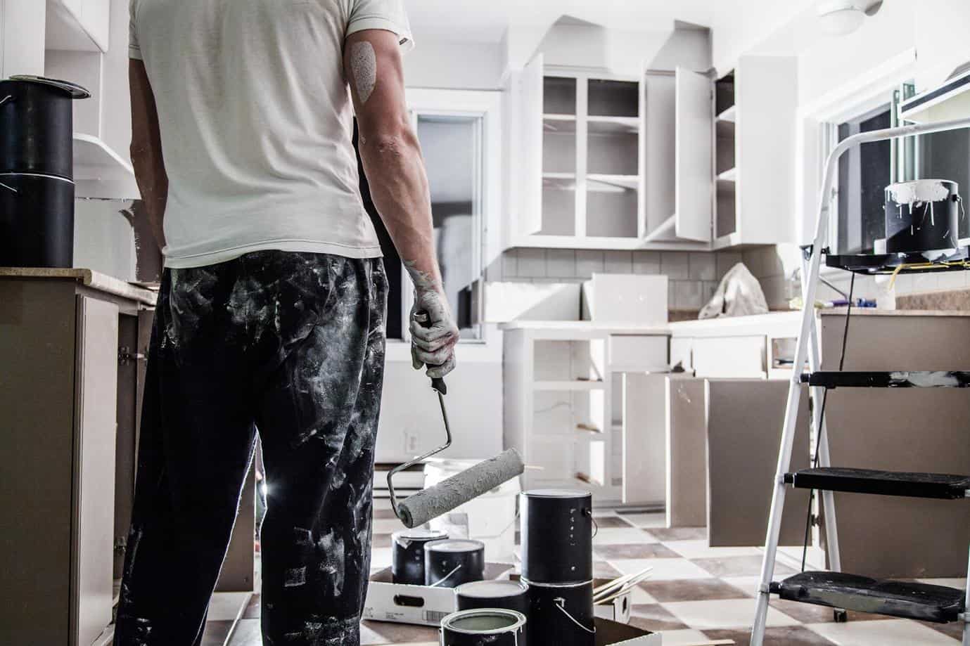 do you need a permit to remodel a kitchen - man holding paint remodeling the kitchen