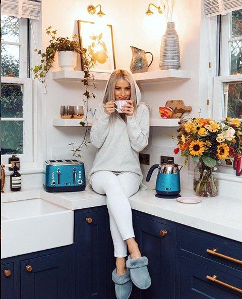 how to become a home decor influencer - influencer sitting down in beautifully designed kitchen while drinking coffee