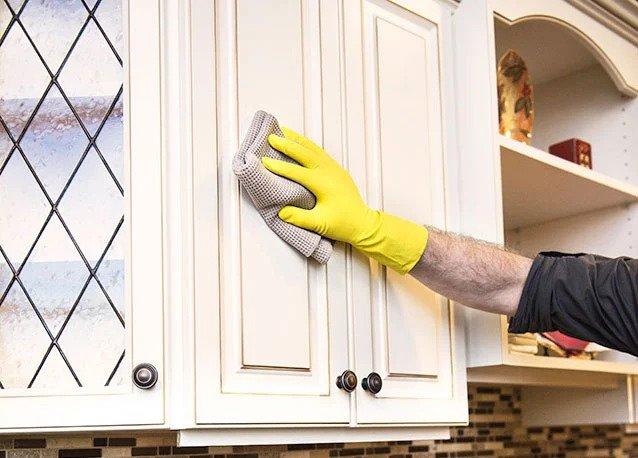 how to fix worn spots on kitchen cabinets - man fixing scratch in cabinet