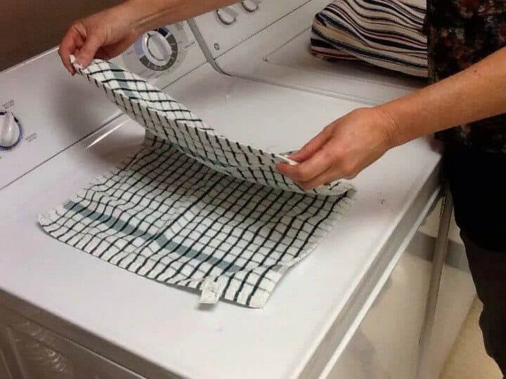how to fold kitchen towels - person folding towel