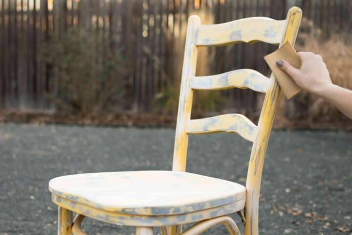 how to paint kitchen chairs - person roughing surface of chair